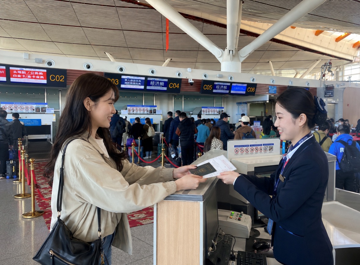 공항 체크인 카운터 풍경 공항 체크인 카운터에서 승객이 직원에게 여권과 탑승권을 건네는 모습
