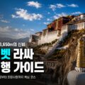 푸른 하늘 아래 높은 언덕 위에 자리한 큰 건축물이 보이고 앞쪽에 황금 장식이 있는 탑이 서 있다.